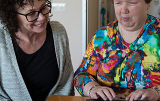 Client en begeleider werken samen met brailleregel
