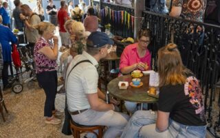 "Cliënten en medewerkers genieten van een lunch in een sfeervolle foyer tijdens de tweede dag van het 40-jarig Coppes Festival."