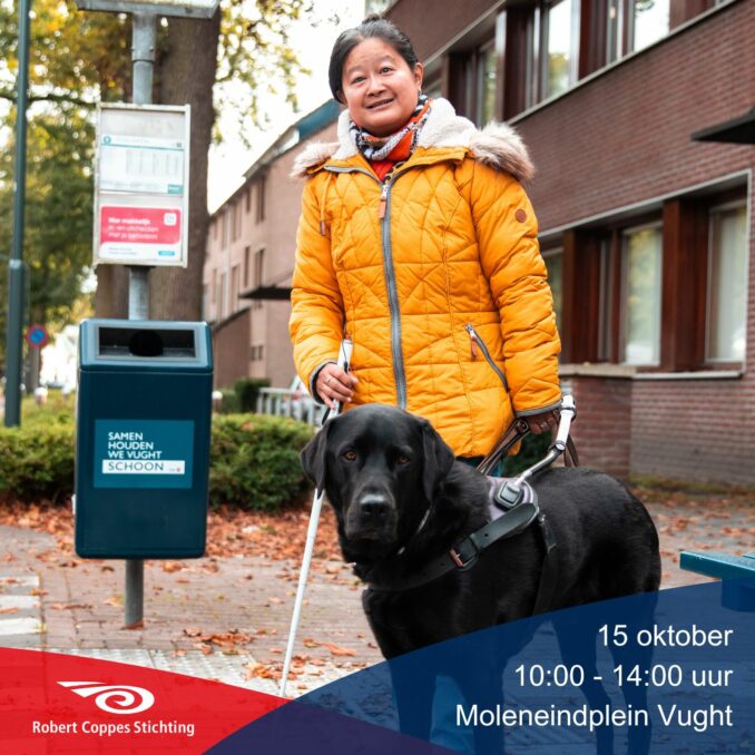 Een vrouw met een visuele beperking staat buiten met haar geleidehond. Ze draagt een gele jas en houdt een witte taststok in haar hand. Naast haar staat een afvalbak met de tekst "Samen houden we Vught schoon." Onderaan de afbeelding staat informatie over een evenement op 15 oktober op het Moleneindplein in Vught, van 10:00 tot 14:00 uur, met het logo van de Robert Coppes Stichting.